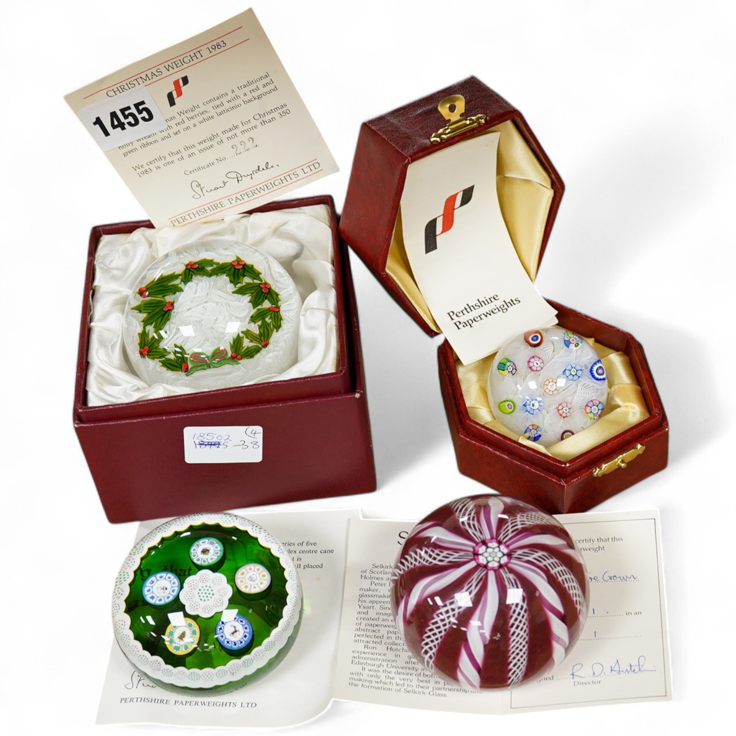 Two Perthshire glass Christmas paperweights for 1981 and 1983, a Perthshire miniature Latticino weight, 18/400, dated 1982, and a Selkirk glass Millefiori crown paperweight, 1982, (4) Largest Perthshire paperweight 8cm